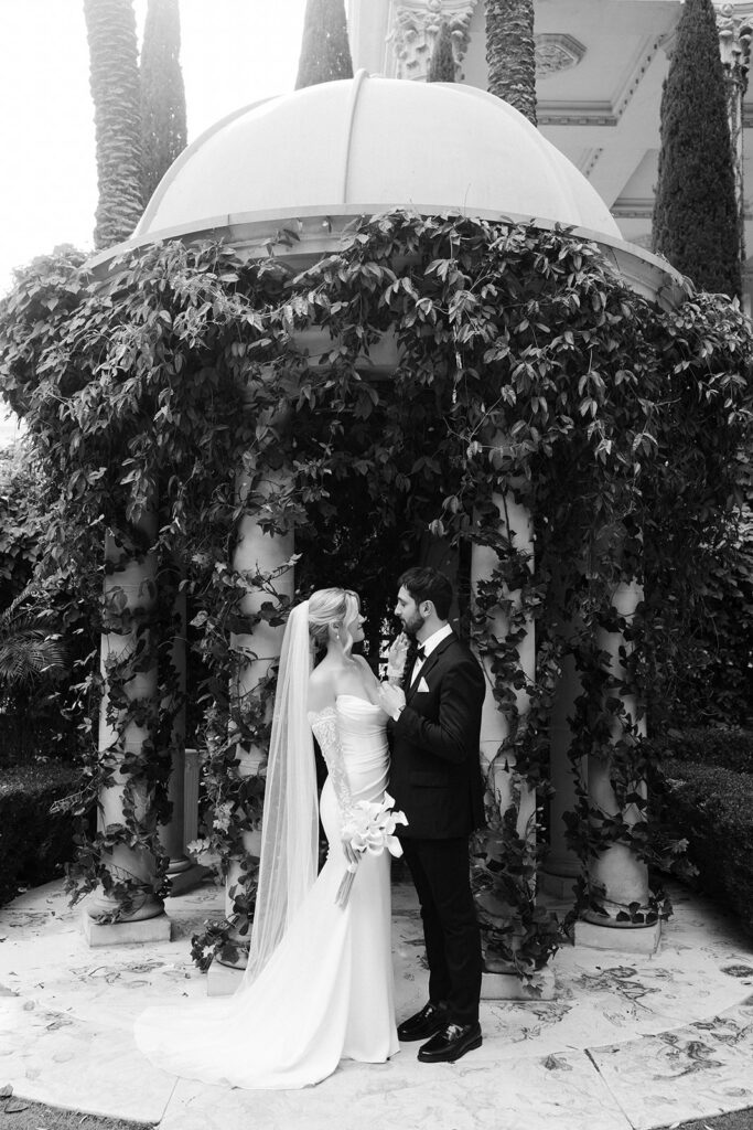 Bride and groom standing together beneath the ivy gazebo after their Venus Garden Chapel at Caesars Palace wedding ceremony.