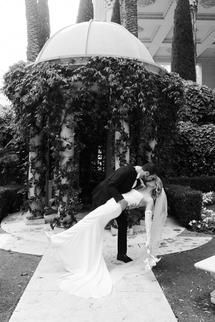 Bride and groom sharing a dip kiss under the gazebo at the Venus Garden Chapel at Caesars Palace in Las Vegas.