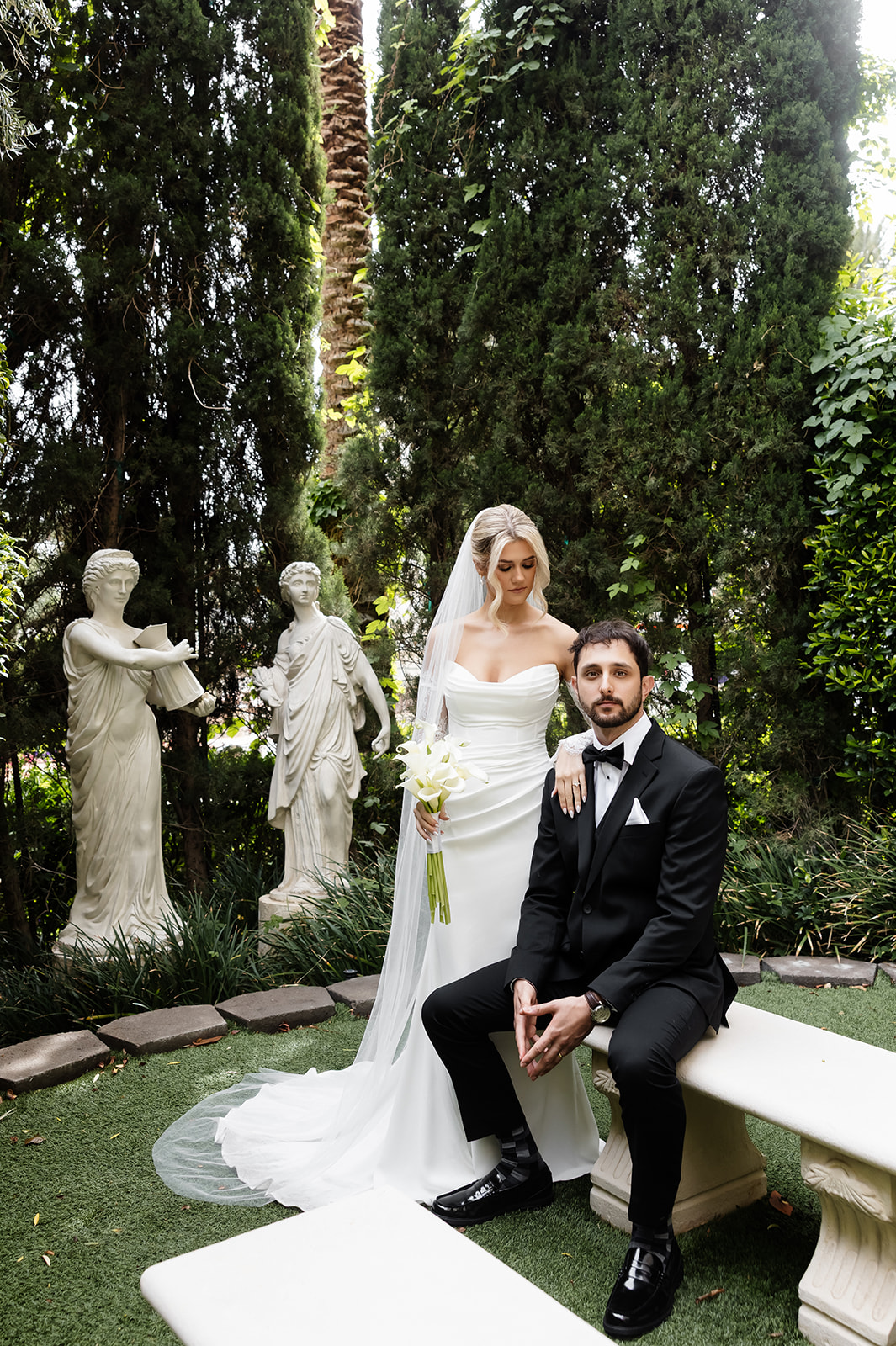 Bride and groom posing on the benches for their Venus Garden Chapel Caesars Palace wedding portraits.