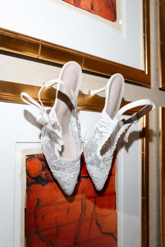 Brides heels hanging of artwork for editorial wedding detail shots.