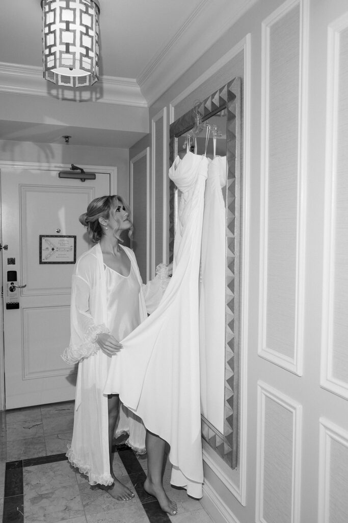 Bride looking at her wedding dress while getting ready in the Caesars Palace suite.