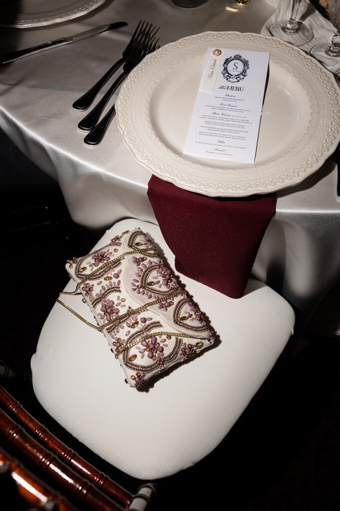 Wedding reception place setting with printed menu and burgundy napkin at the Canaletto Las Vegas wedding reception.