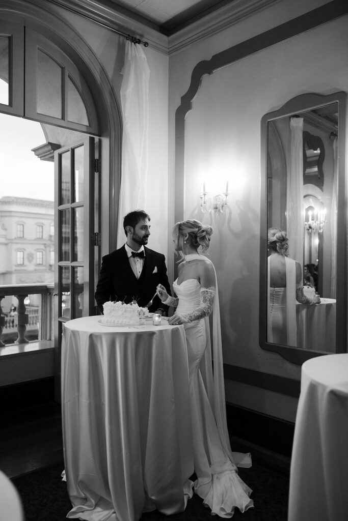 Newlyweds standing beside their cake table during their Canaletto Las Vegas wedding reception.