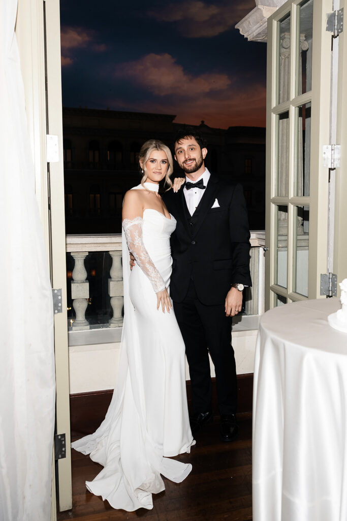 Bride and groom posing on the balcony during their Canaletto Las Vegas wedding reception.