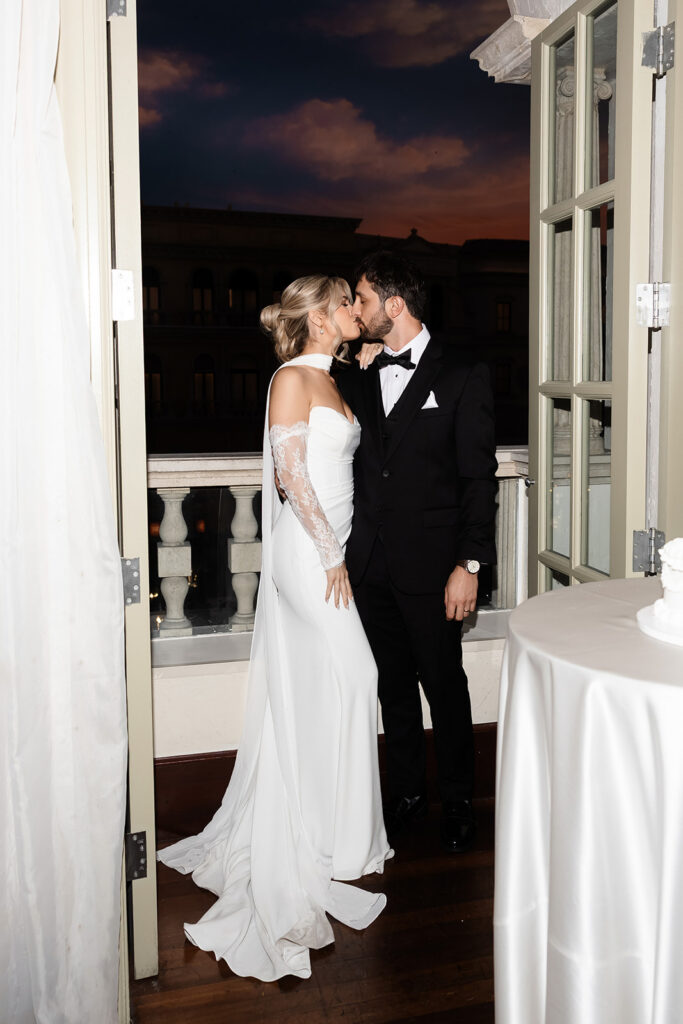 Bride and groom kissing on the balcony during their Canaletto Las Vegas wedding reception.