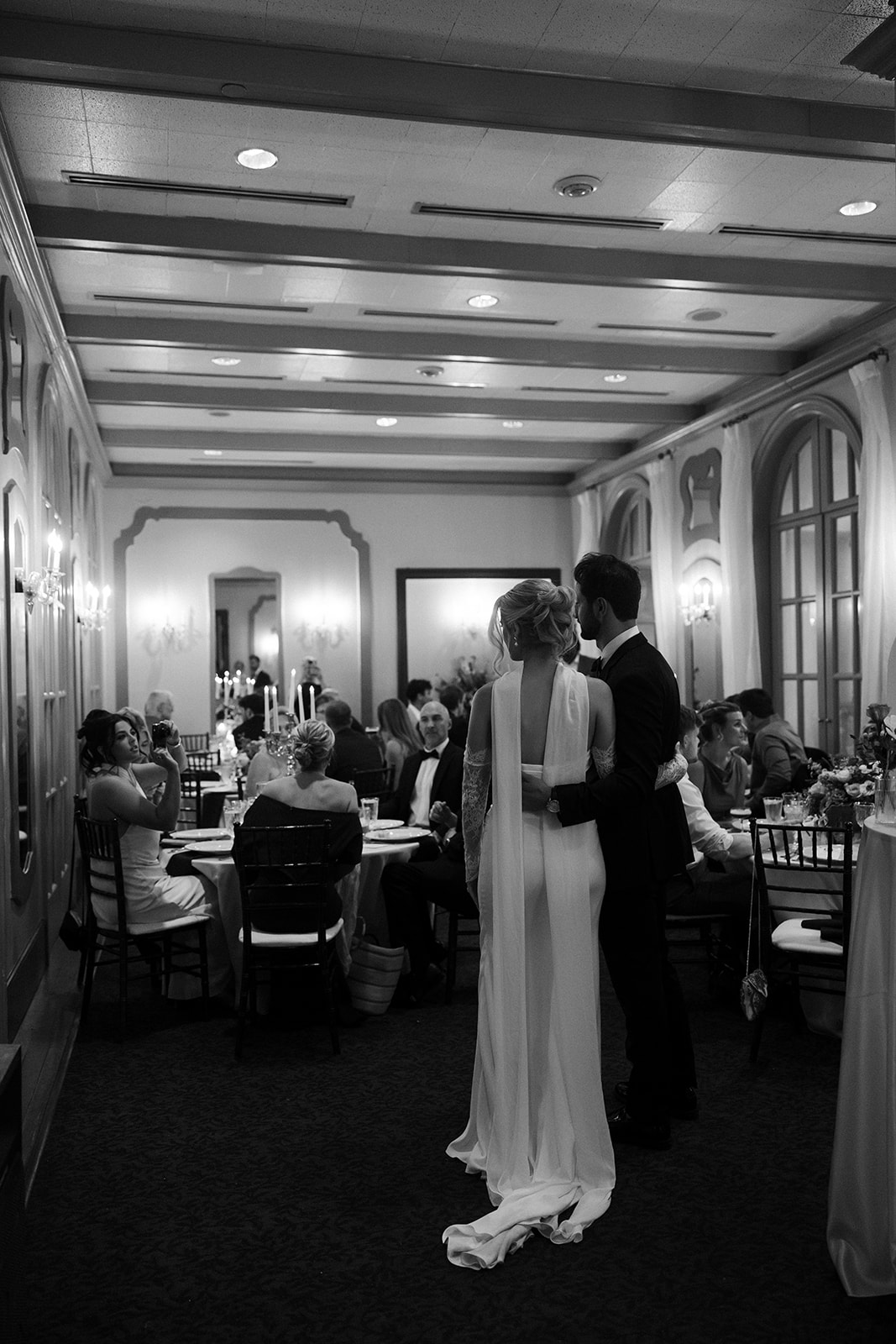 Bride and groom standing together admiring their guests during their Canaletto Las Vegas wedding reception.