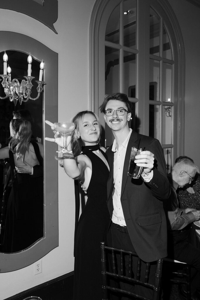 Black and white photo of guests posing with drinks for a photo during a Canaletto Las Vegas wedding reception.