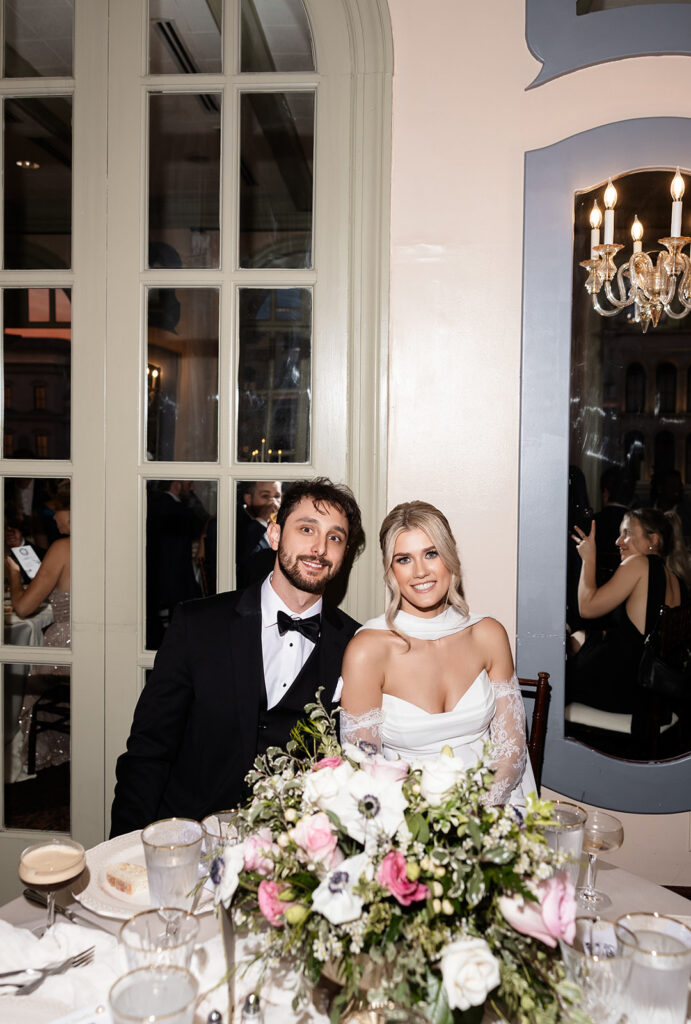 Bride and groom seated together at their reception table during their Canaletto Las Vegas wedding reception.