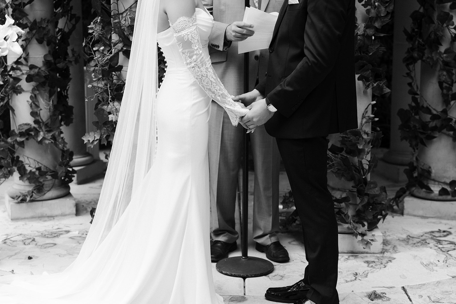 Bride and groom holding hands during their outdoor wedding ceremony at the Venus Garden Chapel at Caesars Palace.