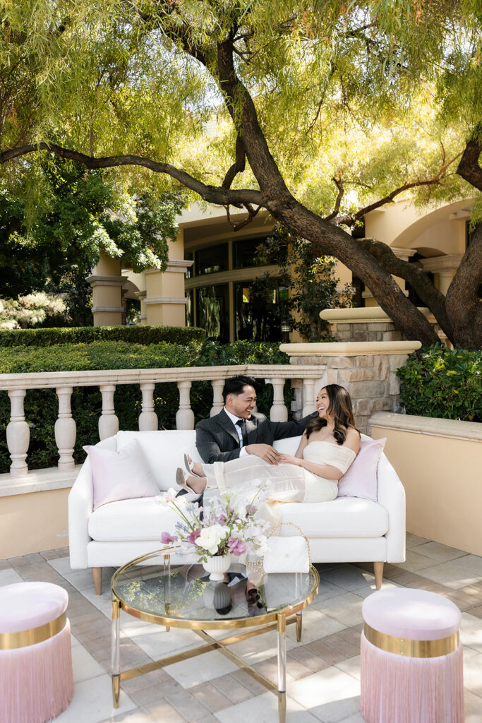 Bride and groom sitting together on outdoor couch during luxury Las Vegas wedding content creator styled shoot.