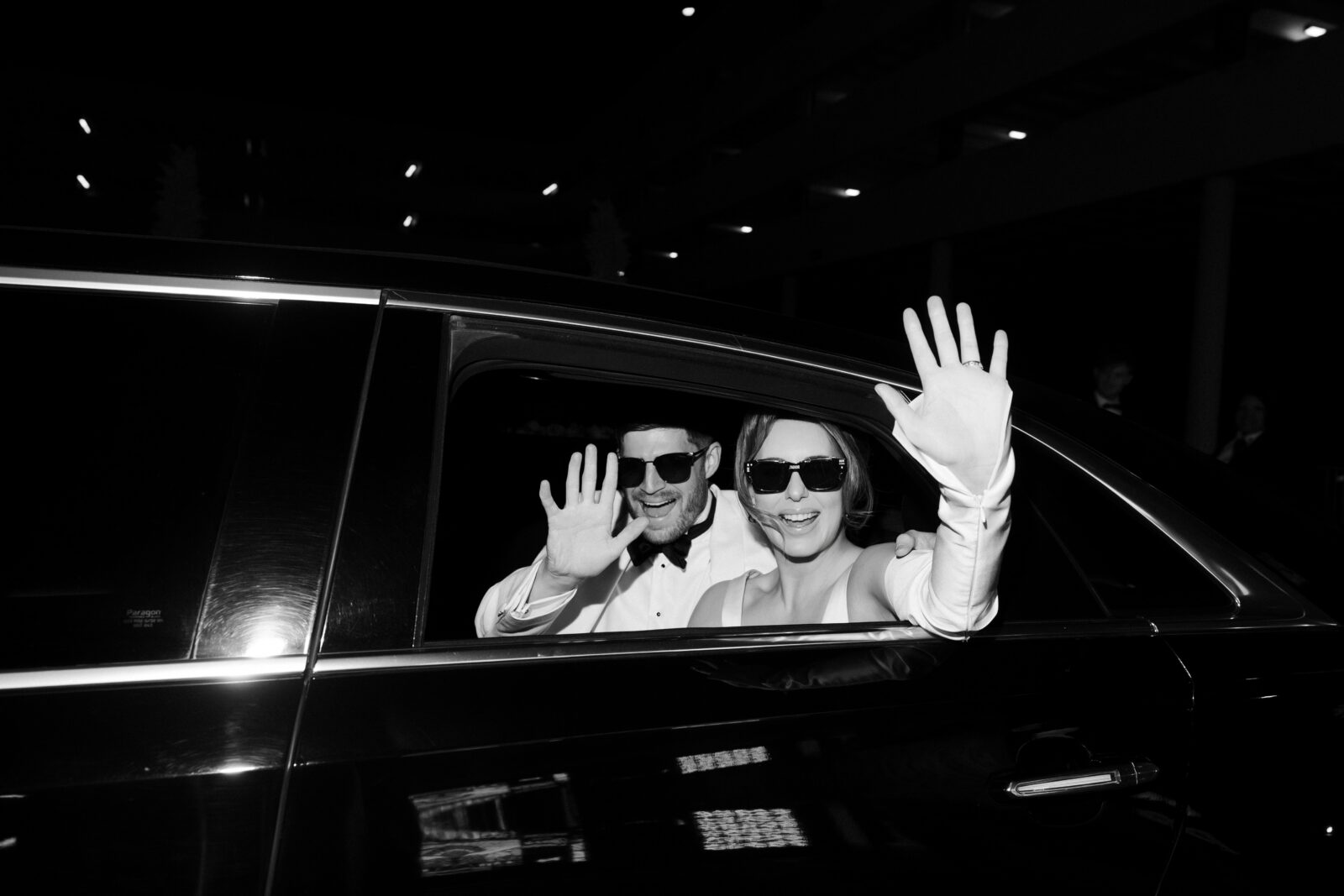 Bride and groom waving at the camera from their limo during their luxury elopement in Las Vegas. 