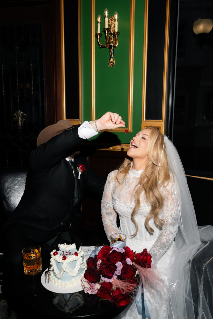Groom feeding the bride a cherry off of their cake during their intimate Las Vegas weddind.