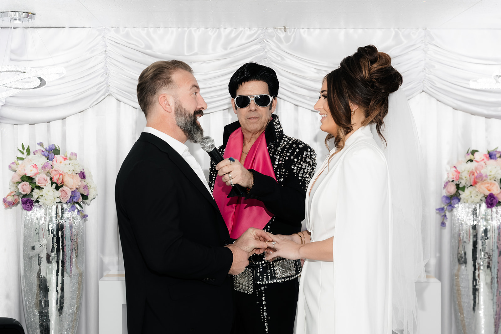 Bride and groom exchanging vows with an Elvis officiant during their Las Vegas chapel elopement ceremony.