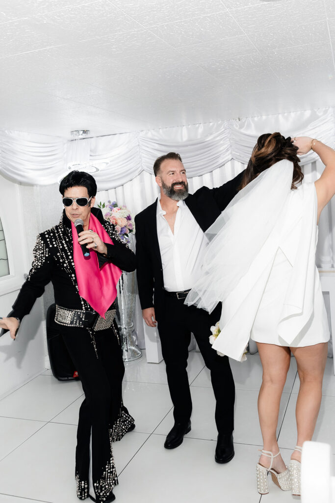 Bride and groom dancing as the Elvis impersonator sings during their Little White Chapel elopement in Las Vegas. 