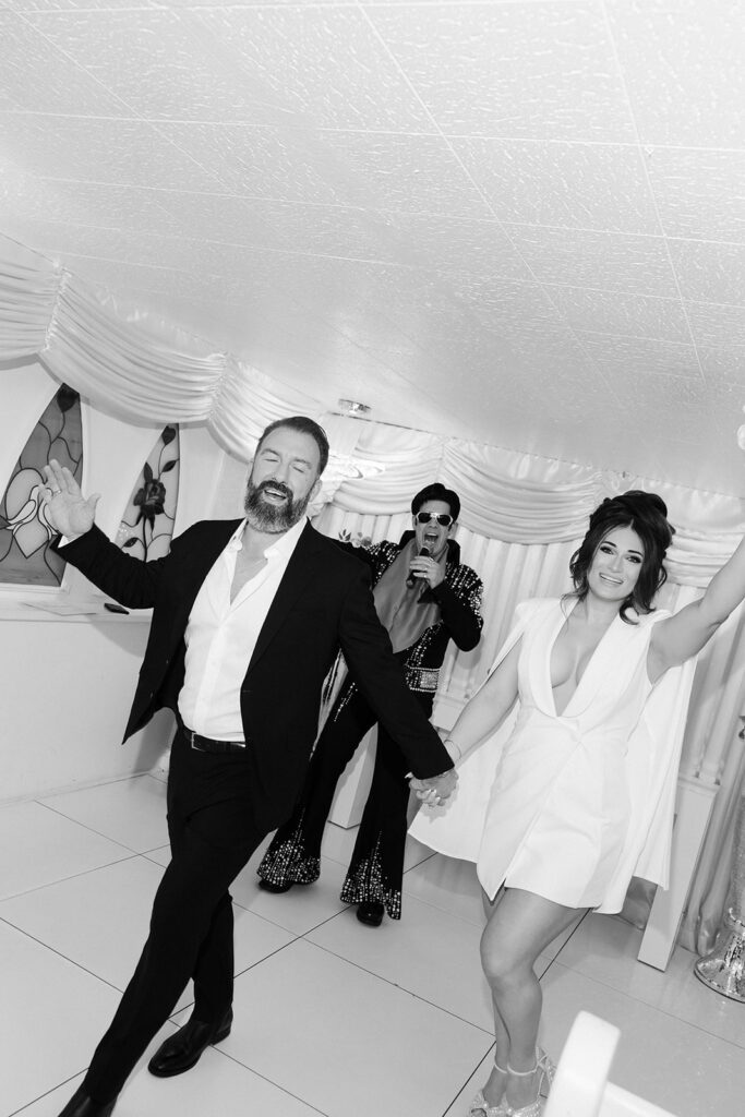 Black and white photo of a bride and groom walking back down the aisle as husband and wife at The Little White Wedding Chapel in Las Vegas. 