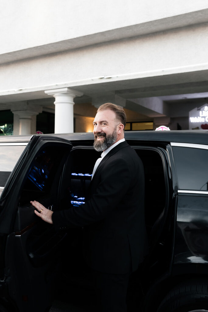 Groom stepping into a limousine outside The Little White Wedding Chapel after their Las Vegas elopement ceremony.