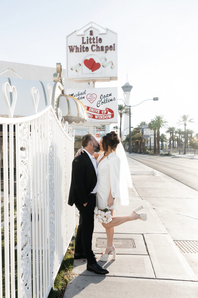 Bride and groom kissing outside of The Little White Wedding Chapel in Las Vegas.