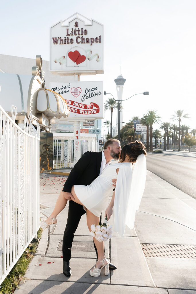 Bride and groom kissing outside of The Little White Wedding Chapel in Las Vegas.