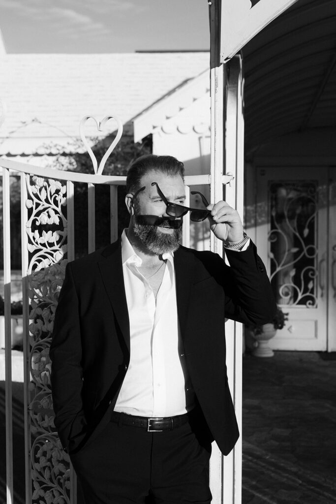 Groom wearing sunglasses during portraits outside The Little White Wedding Chapel in Las Vegas.