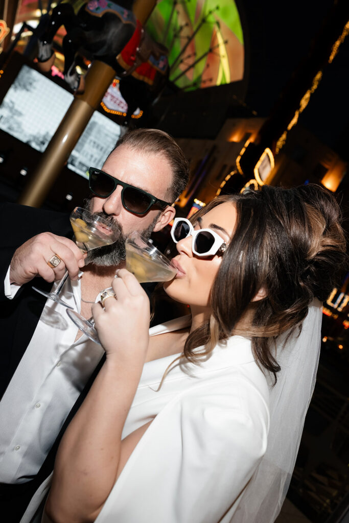 Bride and groom drinking martinis together on Fremont Street during their Las Vegas luxury elopement.