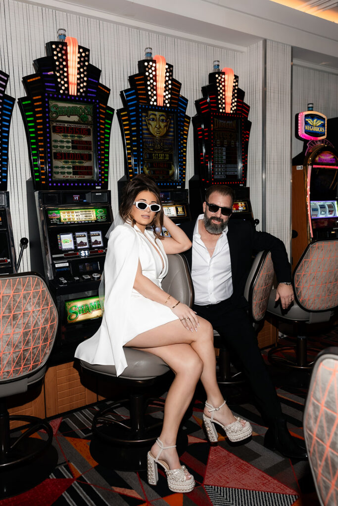 Bride and groom posing at Las Vegas slot machines during their downtown Fremont Street elopement photos.
