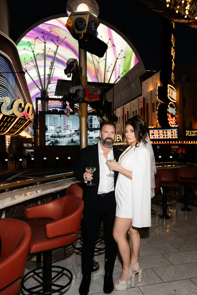 Bride and groom posing with cocktails at Carousel Bar on Fremont Street during their Las Vegas luxury elopement.