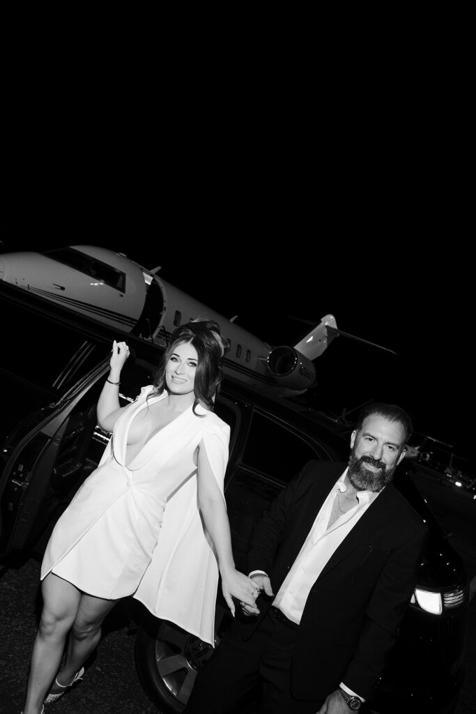 Bride and groom stepping out of a car in front of a private jet during their Las Vegas luxury elopement.