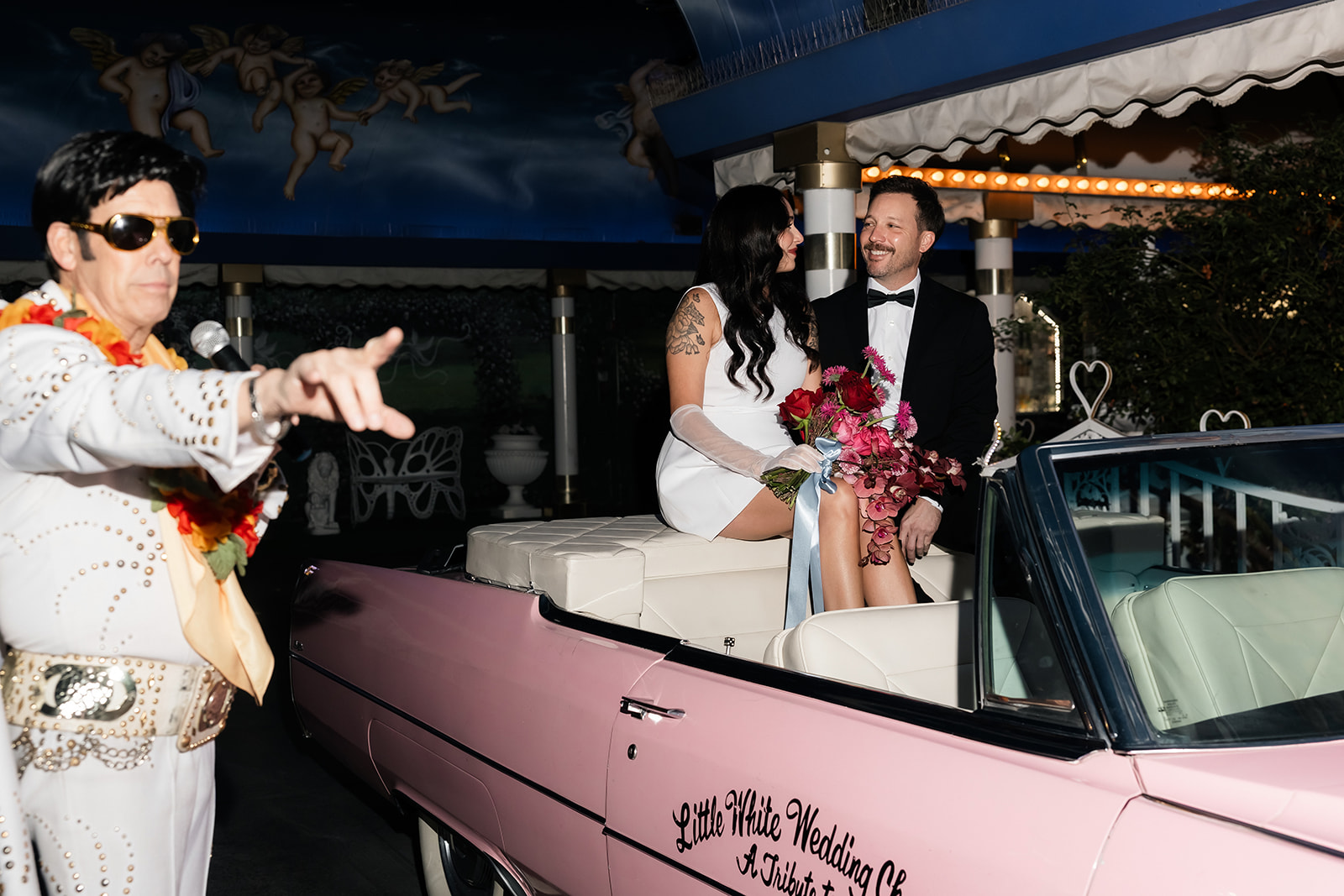 Bride and groom sitting in the back of the Pink Cadillac for their Las Vegas Elvis vow renewal. 