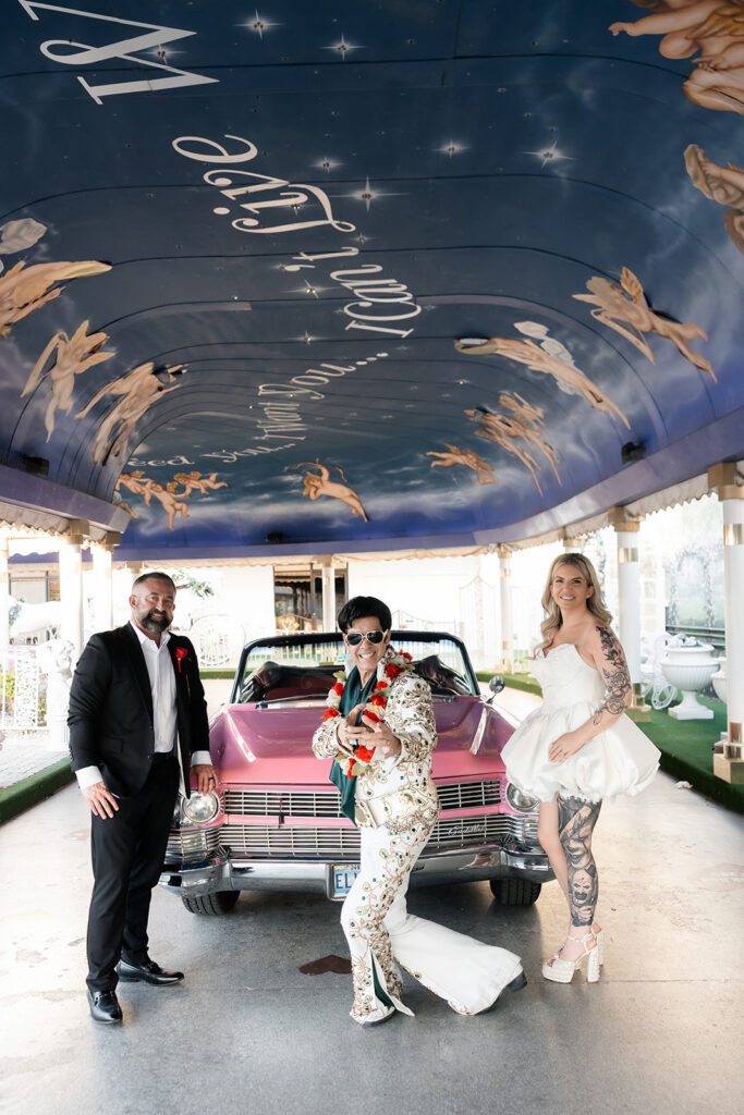 Bride and groom posing with Elvis and the Pink Cadillac at The Little White Wedding Chapel for their Las Vegas vow renewal.