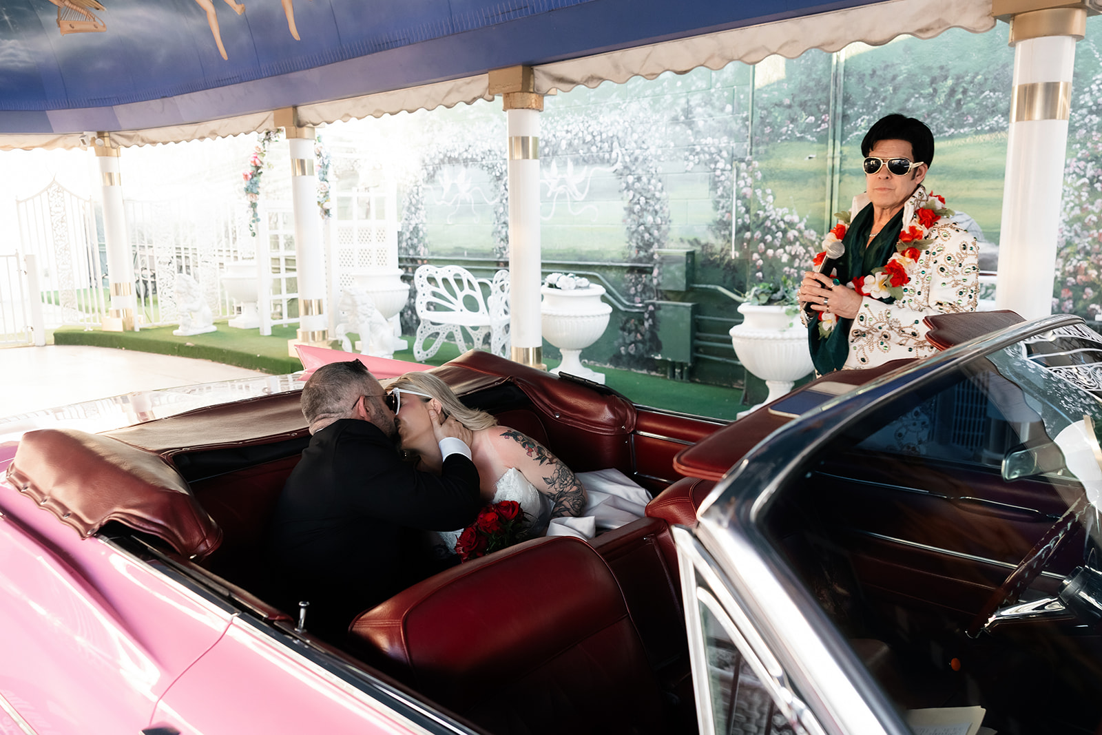 Bride and groom kissing in the back of the Pink Cadillac during their Elvis Las Vegas vow renewal.