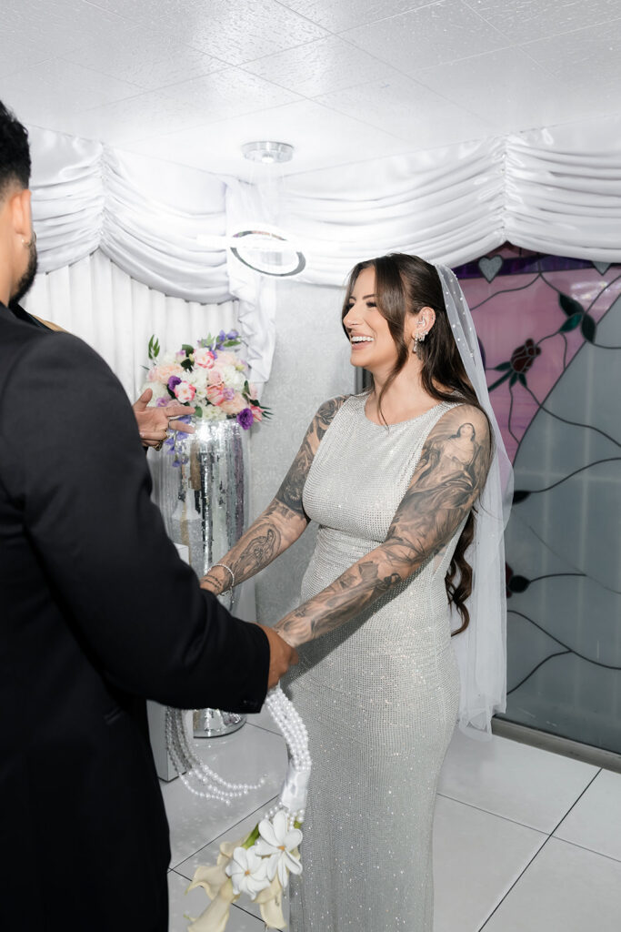 Bride and groom holding hands during their vow renewal at The Little White Wedding Chapel.