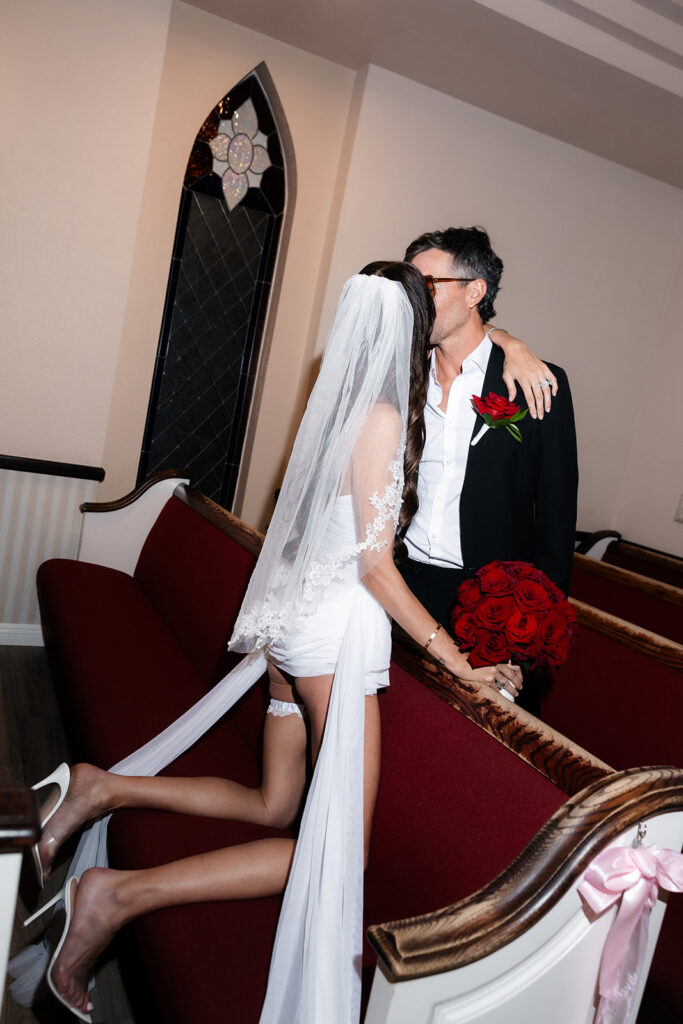 Bride and groom kissing in the benches at A Special Memory Wedding Chapel.