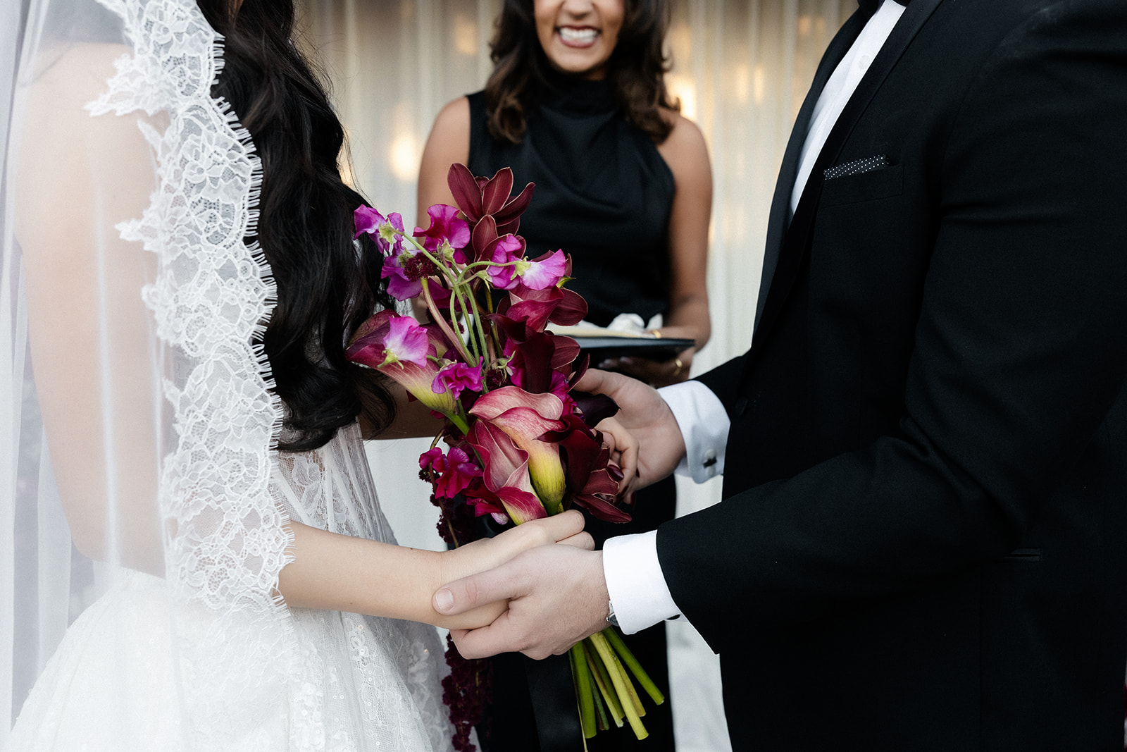 Close up shot of a bride and groom holding hands during their ceremony.