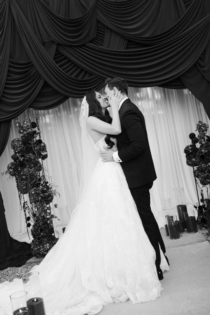 Bride and groom kissing after their ceremony at The Lotus House in Las Vegas under The Pergola.