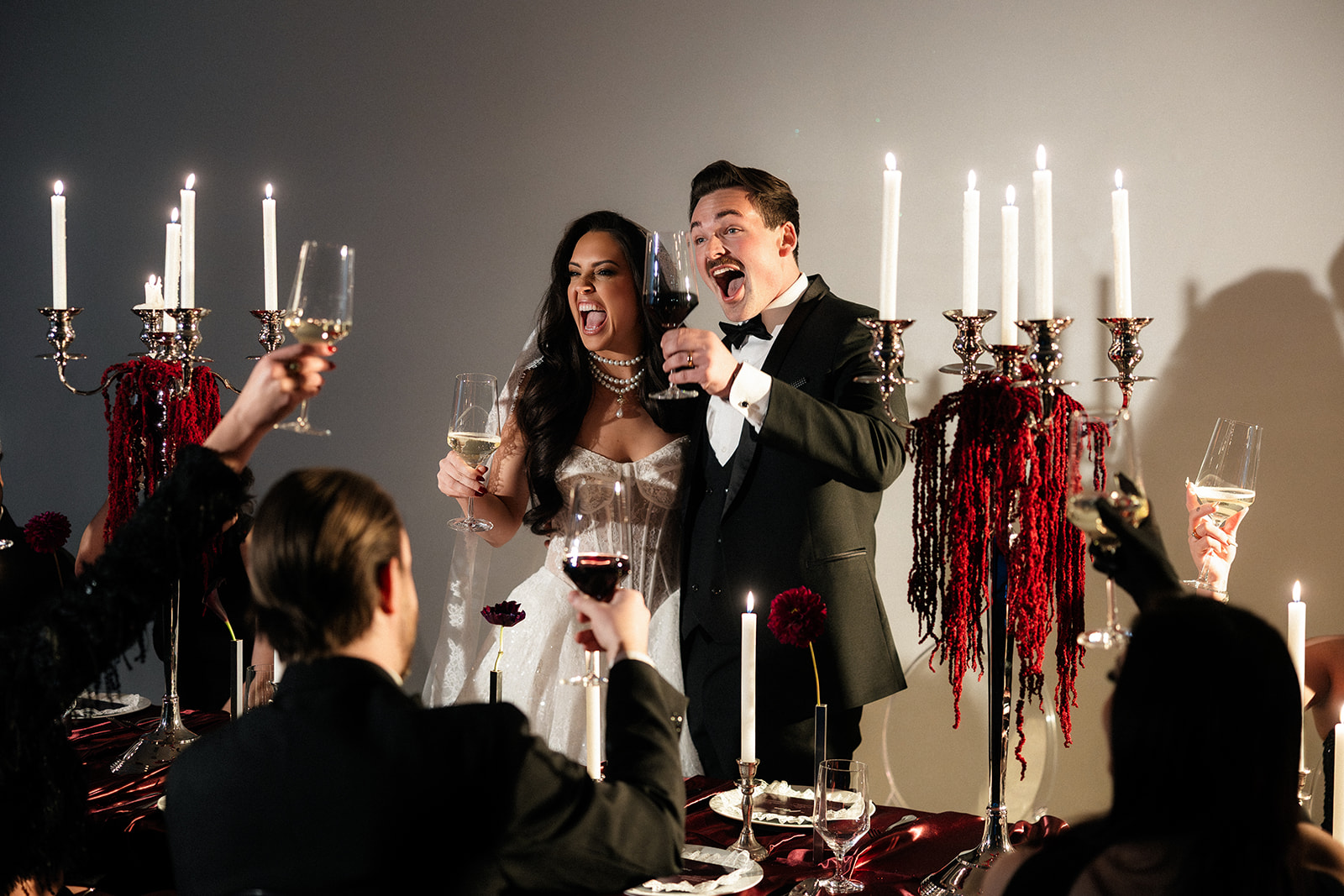 Bride and groom cheering with guests at candlelit reception at The Lotus House wedding venue in Las Vegas.