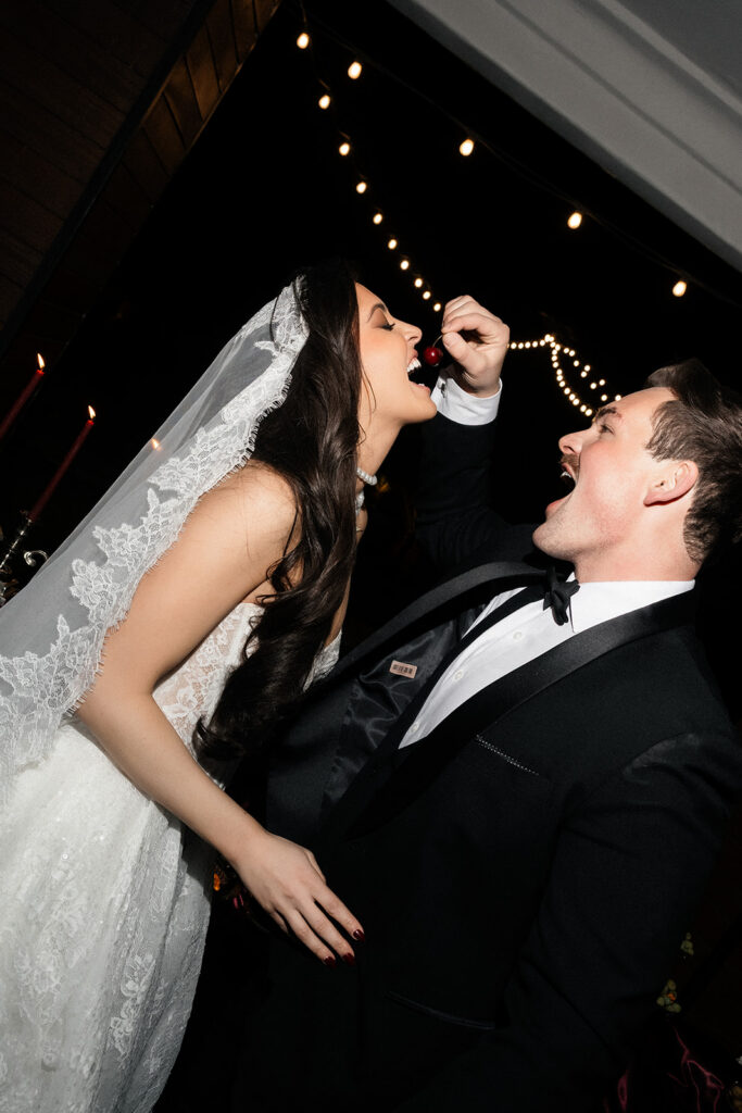 Groom feeding the bride a cherry during their Las Vegas wedding reception.