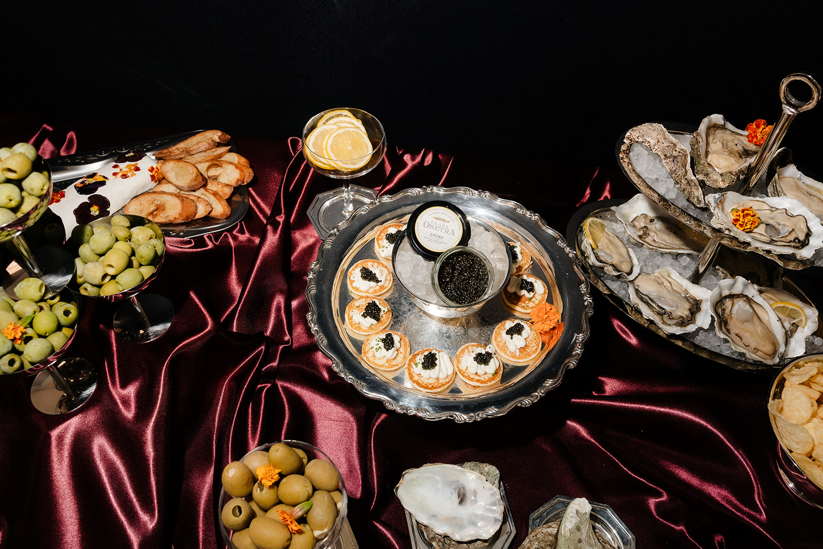 Luxury wedding reception food display with oysters, caviar, olives, and cocktails at The Lotus House wedding venue in Las Vegas.