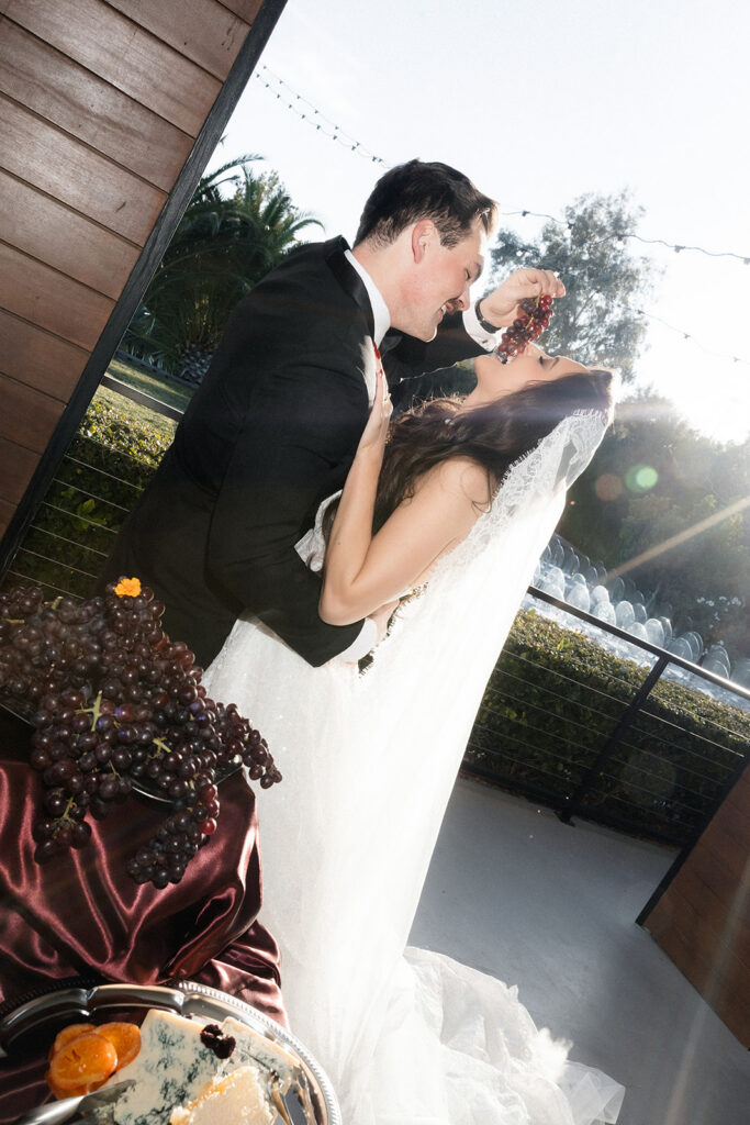 Groom feeing the bride grapes during their Las Vegas wedding reception at Thew Lotus House.