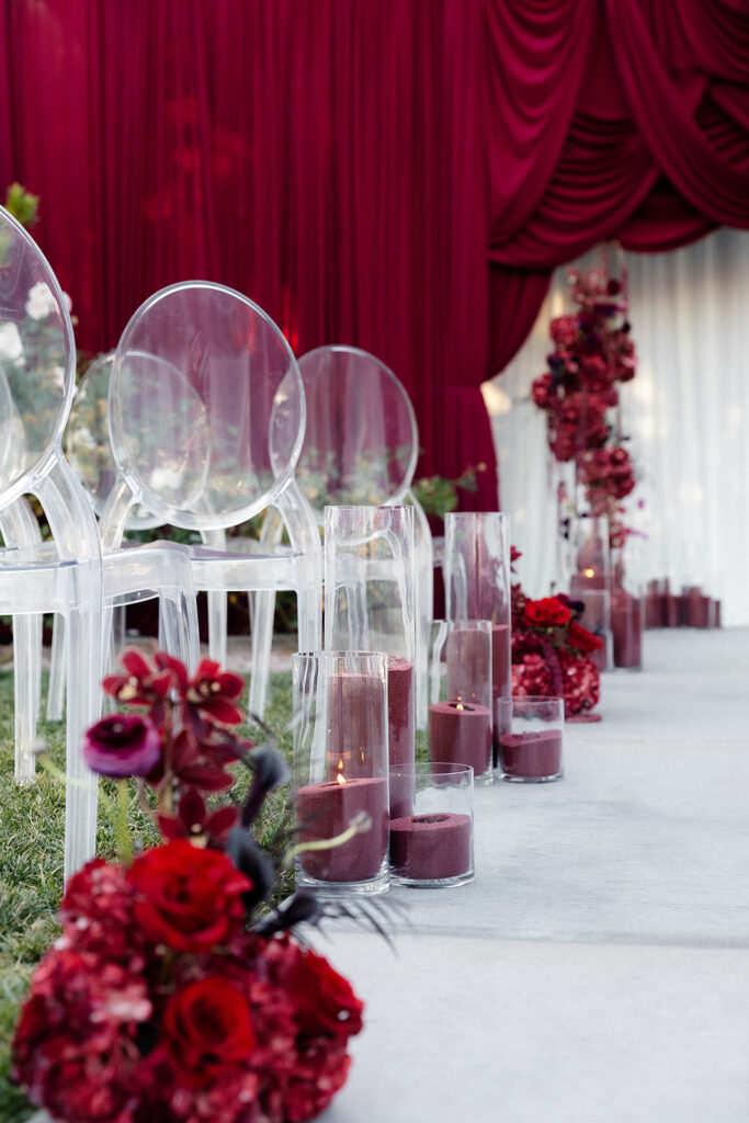 Moody and romantic outdoor wedding ceremony setup with red florals and candles at The Pergola at The Lotus House in Las Vegas.
