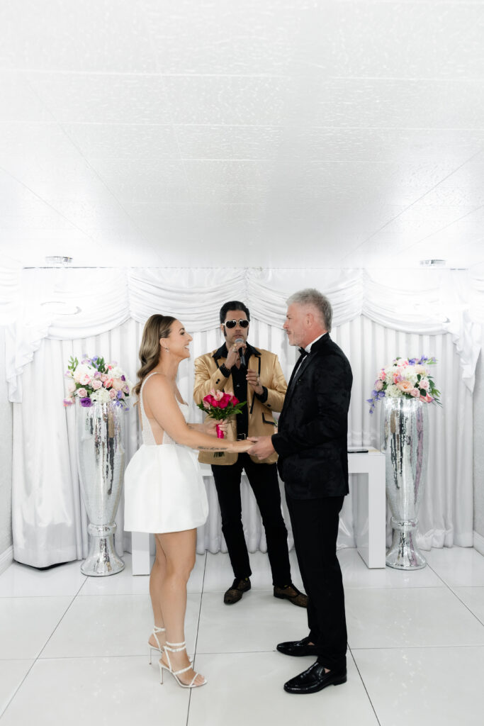 Bride and groom holding hands during their Elvis vow renewal in Las Vegas. 