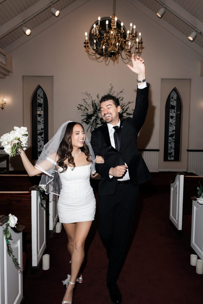 Bride and groom walking back down the aisle in excitement after their ceremony.