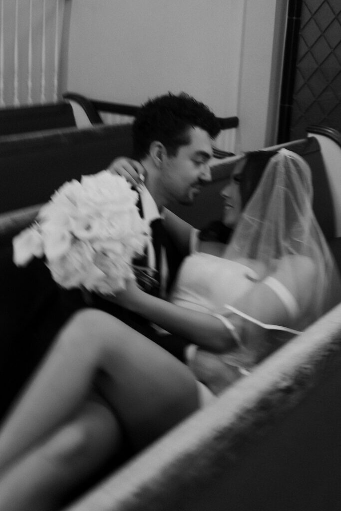 Black and white photo of a bride and groom posing inside the chapel.