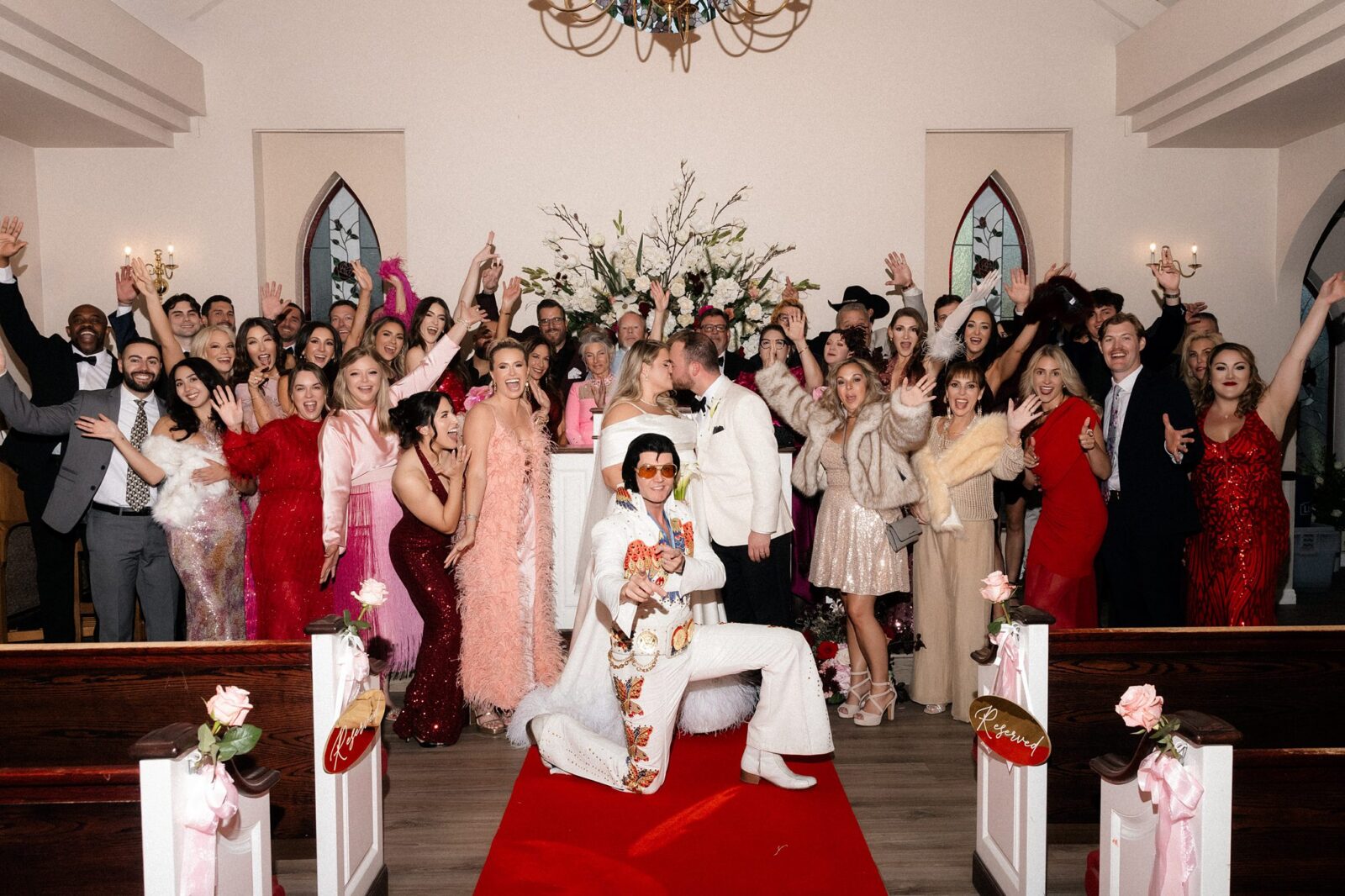 Bride and groom kissing while surrounded by their friends and family after their Elvis wedding ceremony at A Special Memory Wedding Chapel in Las Vegas.
