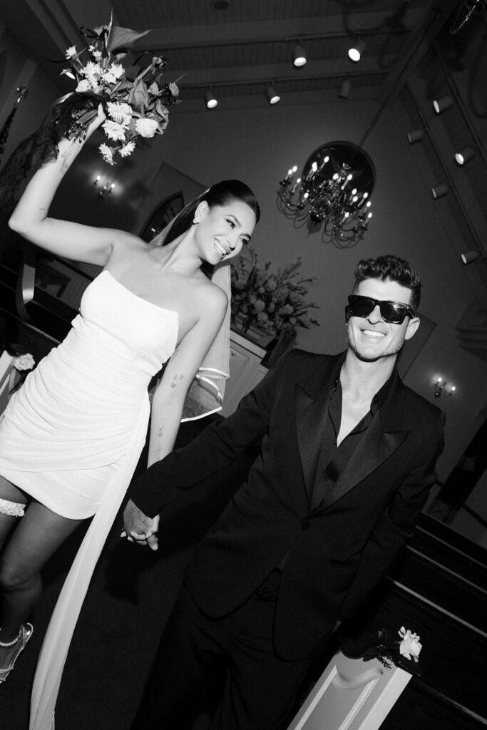 Black and white photo of April Love Geary and Robin Thicke walking back down the aisle after their photoshoot at A Special Memory Wedding Chapel in Las Vegas/