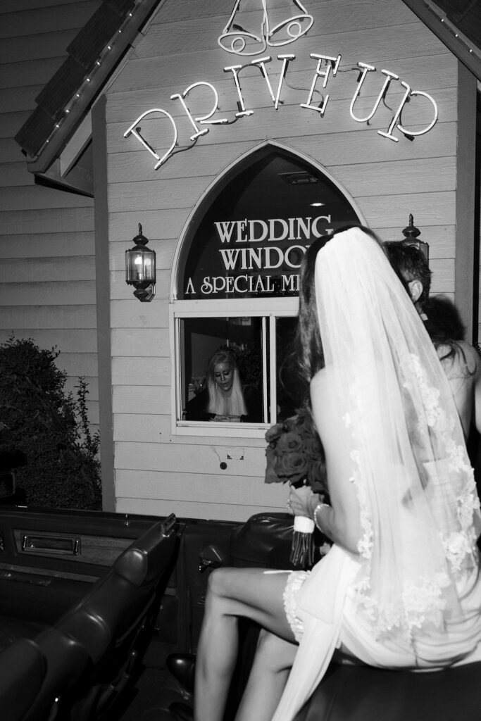 Black and white photo of a couple renewing their vows at the drive-thru window at A Special Memory Wedding Chapel in Las Vegas.
