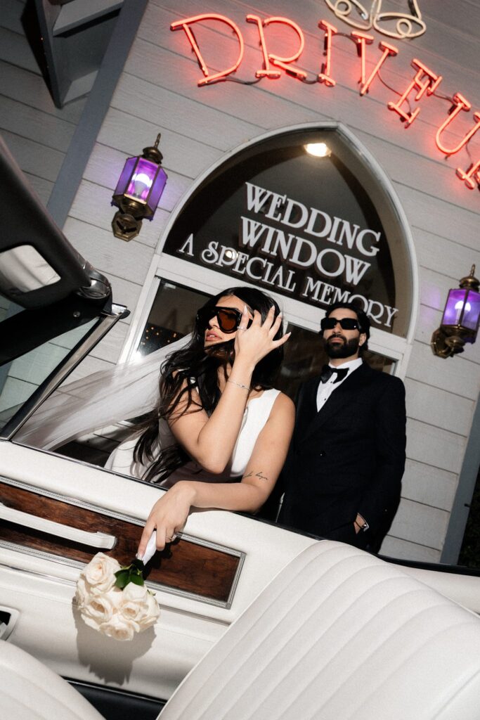 Editorial flash portrait of a bride and groom posing outside of the drive-thru wedding window at A Special Memory Wedding Chapel in Las Vegas.