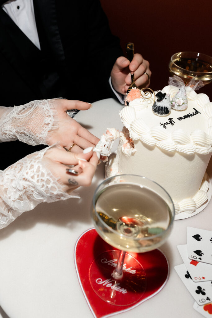 Close up shot of a bride and groom having drinks and cutting into their elopement cake at Carousel Bar in Las Vegas.