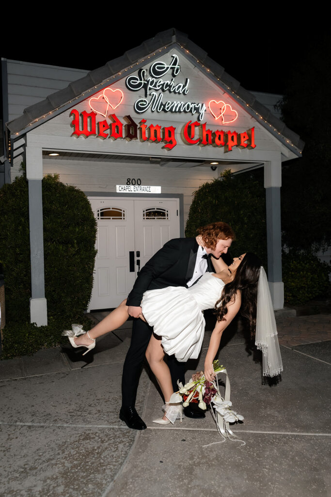 Bride and groom dip kissing in front of A Special Memory Wedding Chapel in Las Vegas.