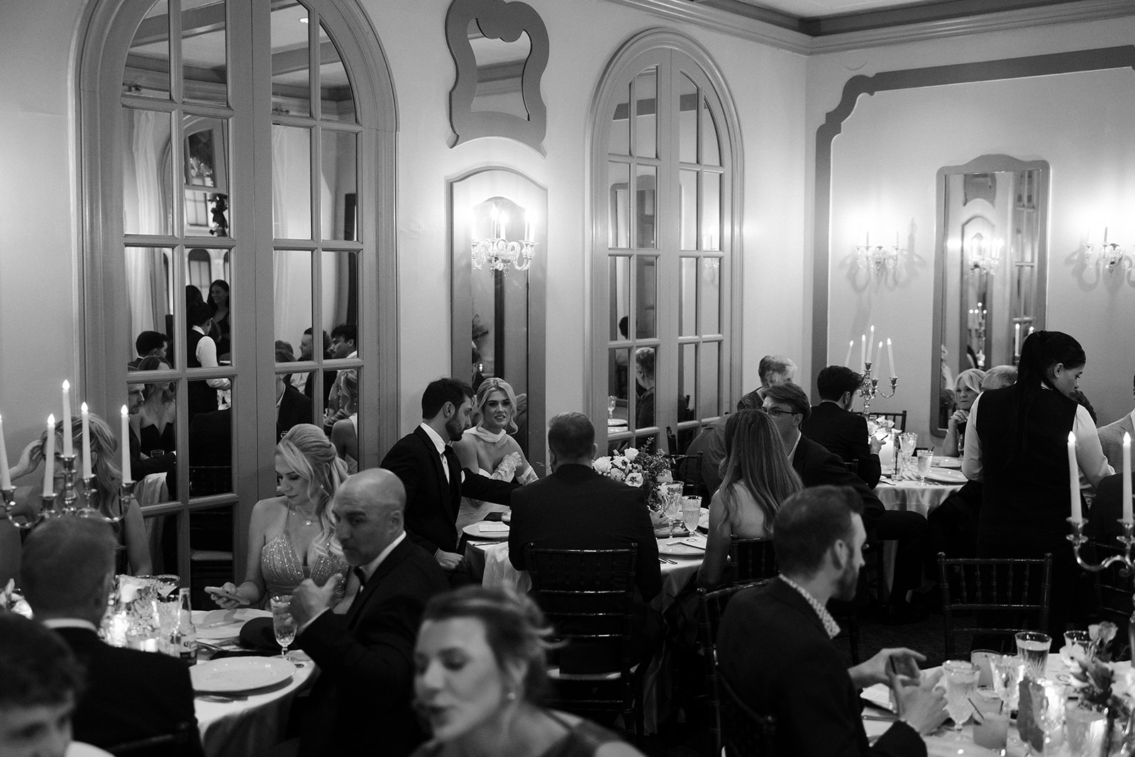 Black and white wide shot of a bride and groom mingling with guests during their Canaletto Las Vegas wedding reception at The Venetian.