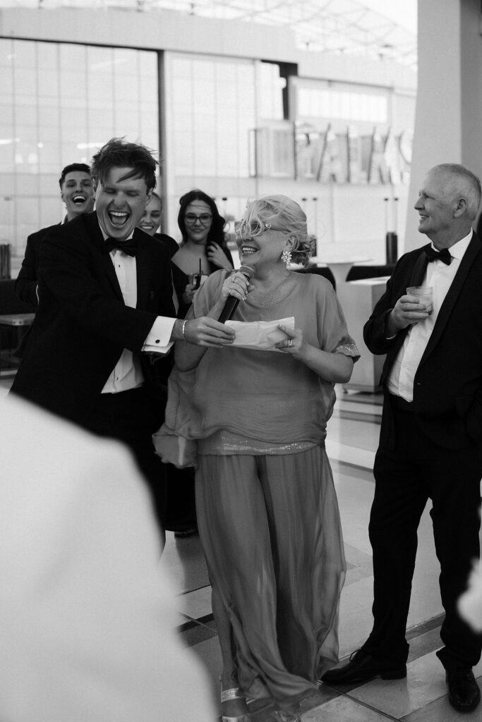 Black and white photo of the grooms parents giving a speech at The Palms Ghostbar.
